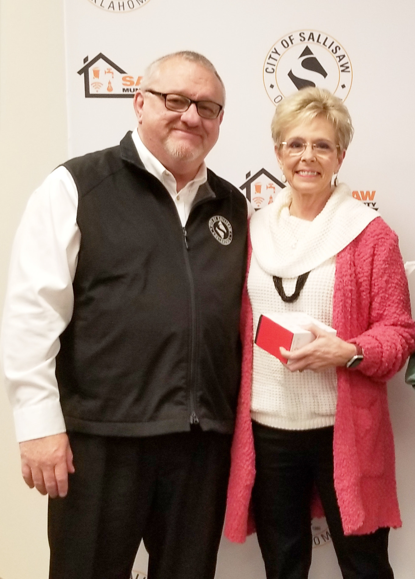 Sallisaw City Manager Keith Skelton presents a gold watch to Debra Washington, who is retiring from the city after 26 years. LYNN ADAMS | TIMES