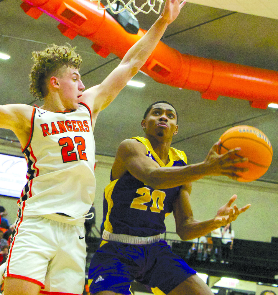 Vian’s Desean Mays goes up for a shot while being defended by Roland’s Carson Wiggins during Saturday’s Class 3A district contest at Roland. On Thursday at Roland the Wolverines play Eufaula at 3 p.m. in a regional consolation quarterfinal game and the Roland Rangers host Stigler at 7:30 p.m. in a regional semifinal game. LEA LESSLEY •TIMES