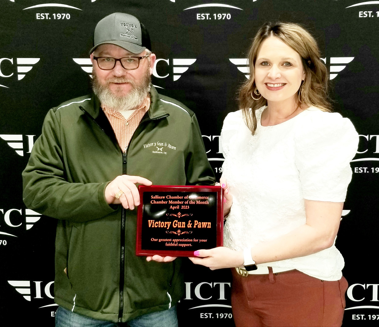 Jeremy Victory (left) of Victory Gun & Pawn accepts the April Member of the Month plaque from Sallisaw Chamber of Commerce president Nikki Garrett. LYNN ADAMS | TIMES