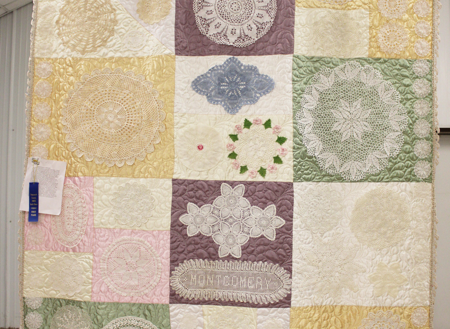 Montgomery Heritage, submitted by Rita Milam, received first place in the mixed techniques division of the recent OHCE Quilt Show at the Sequoyah County Fairgrounds. The quilt, made by her grandmother Montgomery, a seamstress who purchased her first sewing machine from a door-to-door salesman in the 1920s, was made from scraps of wedding dresses and doilies.