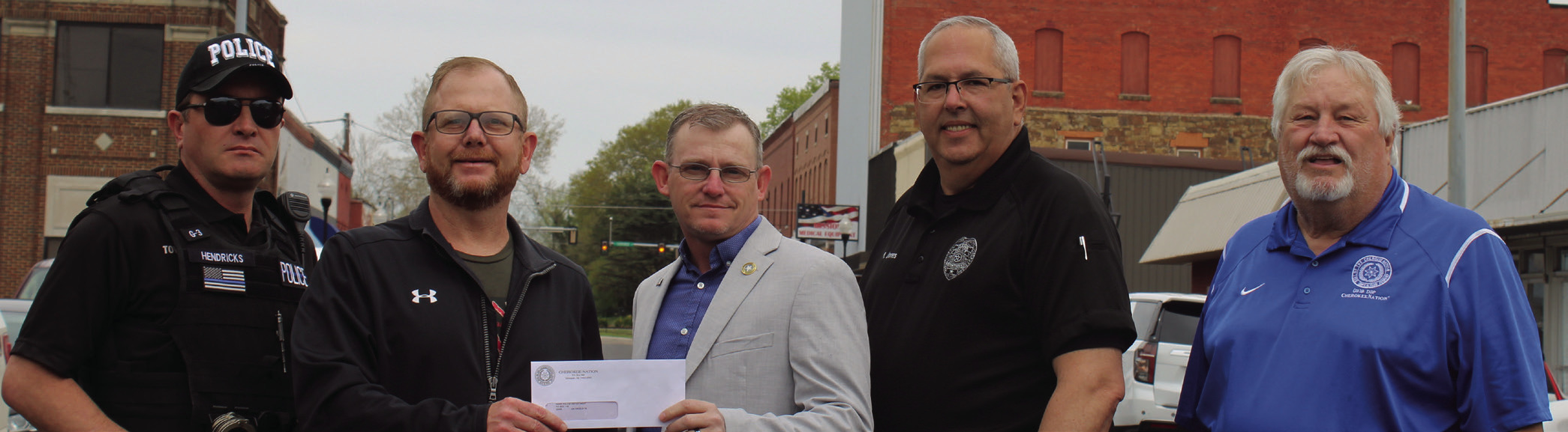 Gans Mayor Gary McGinnis (center), Gans Police Officer Mike Hendricks (left) and Assistant Police Chief Robert Jones receive their $10,000 check from Cherokee Nation Councilmen Daryl Legg (second from left) and E.O. Smith Jr. (right).